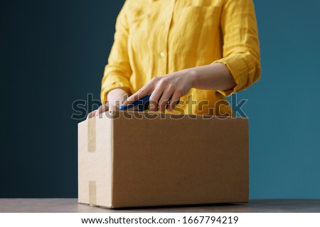 Woman opening a delivery box using a cutter ストックフォト © 
