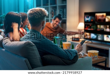 Friends choosing a movie to watch together at home, video on demand concept ストックフォト © 