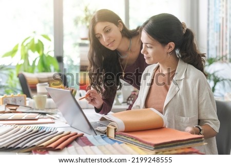 Professional young interior designers and architects working together in the office, they are using a laptop and checking fabric samples Stock fotó © 