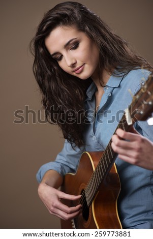 Young female guitarist performing with acoustic guitar