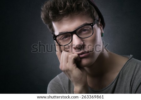 Stylish man with glasses hand on chin looking at camera