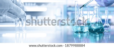 hand of scientist with test tube and flask in medical chemistry lab blue banner background Foto stock © 