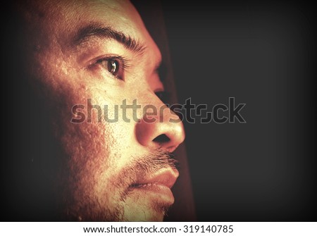 half face portrait of Asian man in the dark
