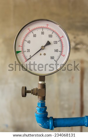 Water pressure meter installed on a blue pipe