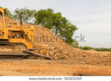 industrial  bulldozer moving earth and sand in sand pit or quarry