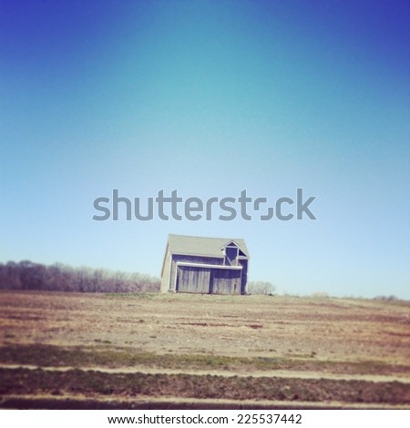 A house sits alone in a vast dirt area.