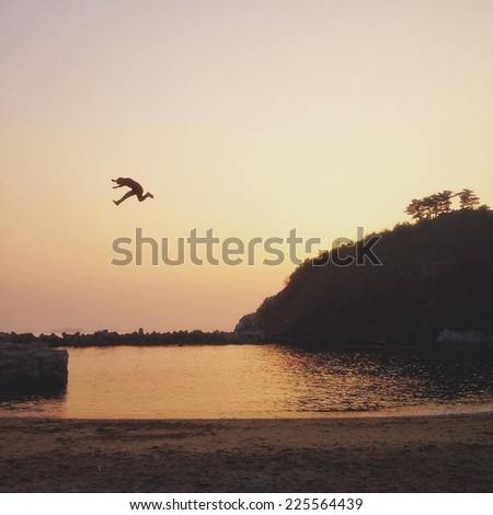 A person in the air above a body of water.