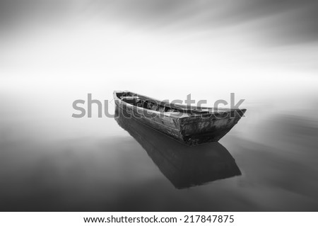 black and white Image of the boat when haze occur at the sea . Motion blur effect at sky . Image has grain or noise and soft focus when view at full resolution