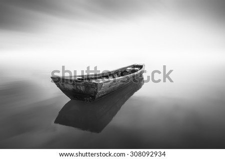 black and white Image of the boat when haze occur at the sea . Motion blur effect at sky . Image has grain or noise and soft focus when view at full resolution