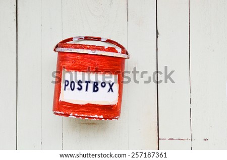 Red mail box on old white wooden door