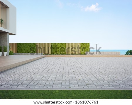 Beach house with empty cobblestone floor for car park. 3d rendering of green grass lawn in modern sea view home.

