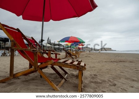 Similar – Image, Stock Photo Umbrellas and empty deckchairs collected on the beach shore in summer.