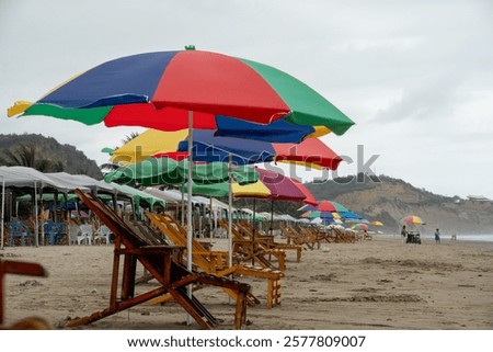 Similar – Image, Stock Photo Umbrellas and empty deckchairs collected on the beach shore in summer.