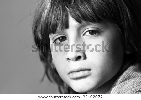 Black and white image of a boy with his sad facial expression. Image signaling to stop violence against children.