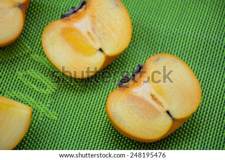 Fresh persimmon slide on black wood black ground