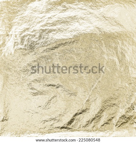 Thin sheet of golden leaf background with shiny uneven surface