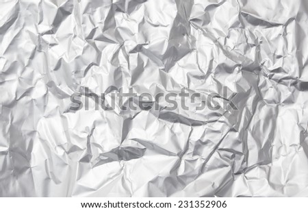 Thin sheet of silver leaf background with shiny crumpled uneven surface