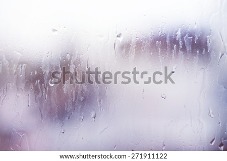 Bright window glass with steam and drops. Colorful backdrop with light leaks
