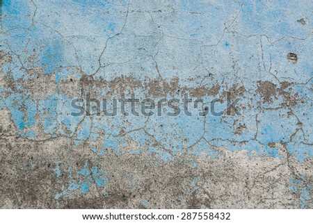 Grunge Background. Wall with the blue colored whitewash falling off fragment with clacks as a background texture