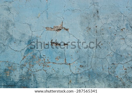 Grunge Background. Wall with the blue whitewash falling off fragment with cracks as a background texture