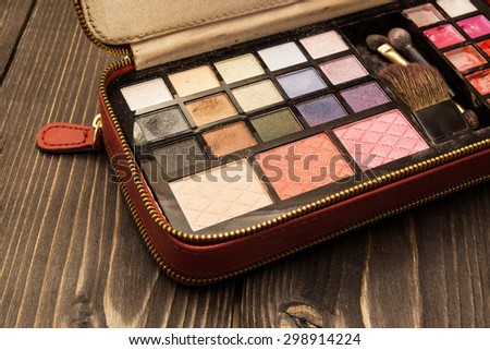 Used cosmetics pallete case isolated on a white wooden table