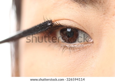Mascara woman putting makeup on eyes.in studio