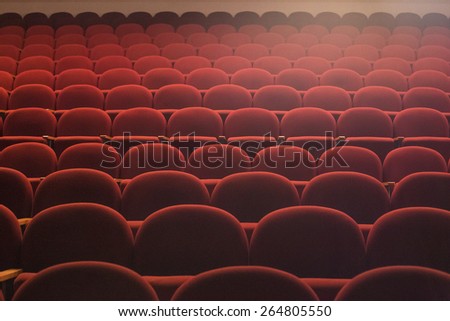 Red seats in theater hall with lens flare