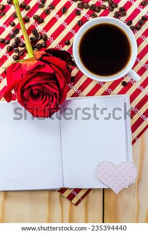 open notepad with roses on striped napkin