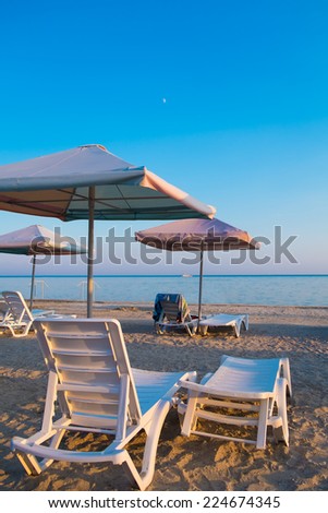 Empty deck loungers in the beach at sunset. Paradise in Ukraine