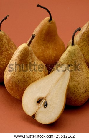 Group uf pears on orange background.Cut pear.Half pear