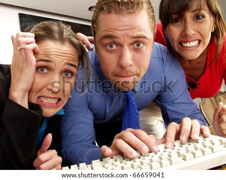 Three worried people watching a computer.