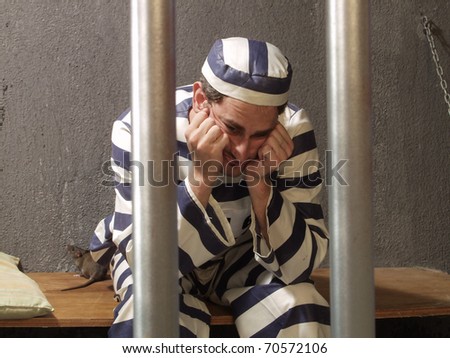 Depressed prisoner in a prison cell.