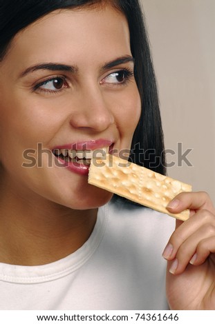 Young woman eating cracker soda cookie. Young woman eating cookie.
