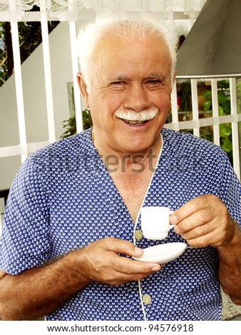 Grand father drinking coffee in a kitchen.
