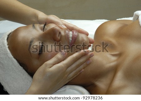 Beautiful young Afro american woman getting a face treatment at beauty salon. Beautiful young black woman getting a face treatment at beauty salon.