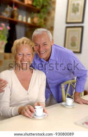 Happy senior couple drinking coffee in the kitchen.