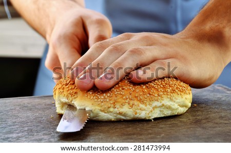 Slicing burger bread and preparing burger.