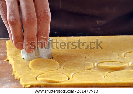 Cook preparing cookies dough using mold.