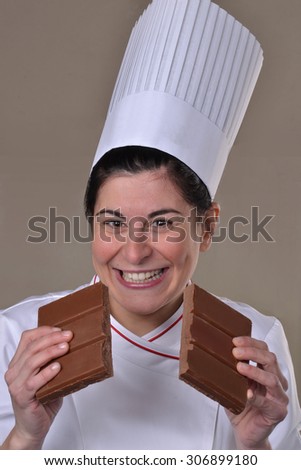 Happy woman cook dividing and holding chocolate stack.Tasting chocolate.