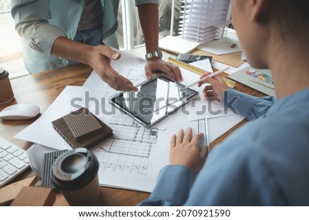 Architects and interior designers women discussing to concept of building design. Estimation for construction project with tablet technology, Drawing, Material and Model. Selective focus center image Foto d'archivio © 