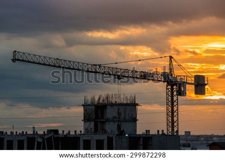 Over view of tower crane in construction machine a sky background, especially in dim light.