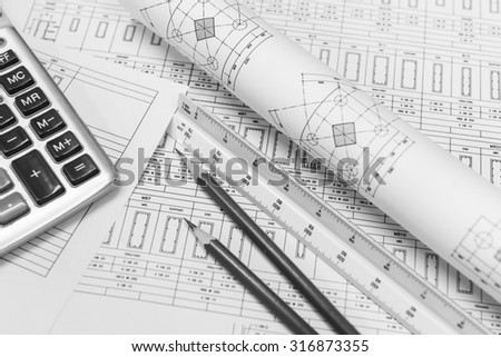 Construction design work.construction drawing paper with the triangular scale ruler, pencil and calculator.black and white color