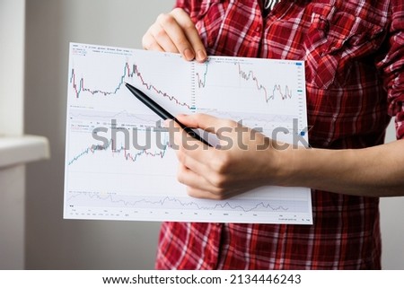 close up of a woman hands explains how to trade on the exchange. It shows on the chart, Business and education concept. Foto stock © 