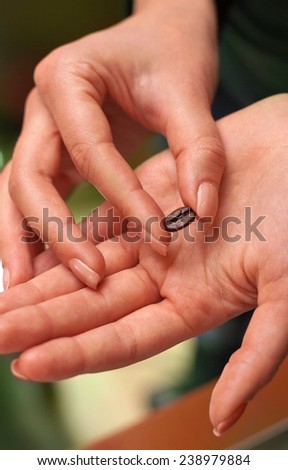 Girl\'s fingers holding a single coffee bean