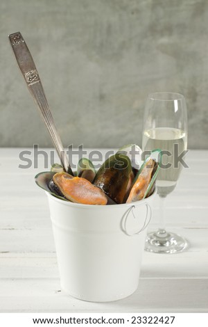 New Zealand mussel in a white tube and old fork and white wine for dinner party.