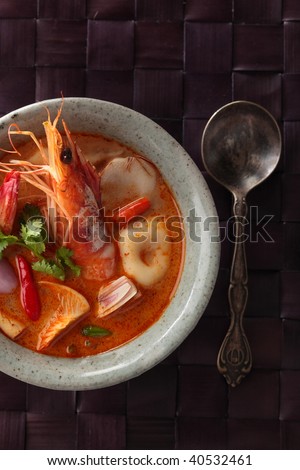 Tom Yum Goong or spicy tom yum soup with shrimp. Thai popular food menu, contained in an ancient bowl.