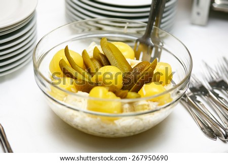real pickles in bowl on restaurant table with plates and forks