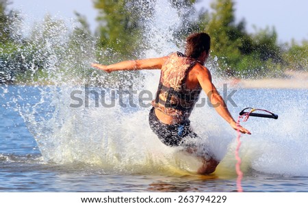 athlete falls in water. Wakeboarder in blackl shorts riding in sunset.