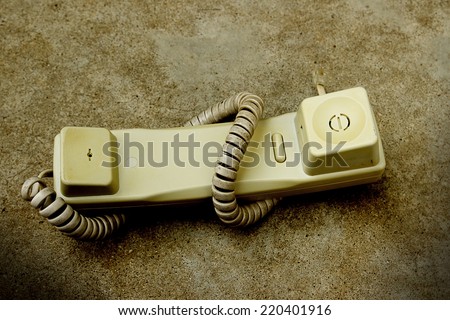 old broken telephone on cement background