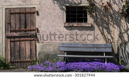 Old Door and a Bench with Flowers